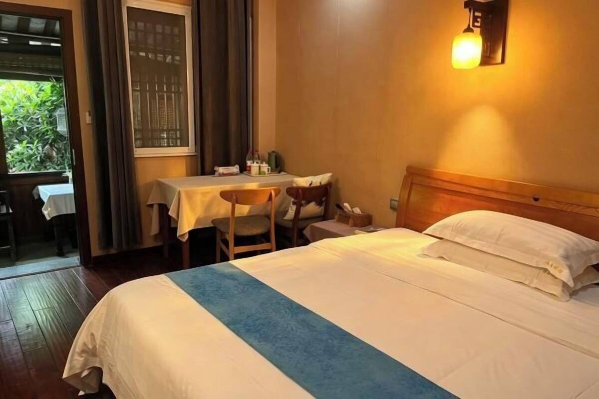 Una habitación de hotel con cama, escritorio y silla.