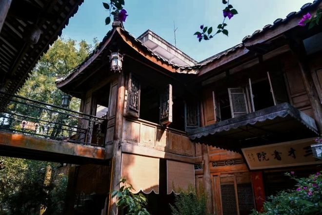 Un edificio de madera tradicional con balcón, una señal y un puente.
