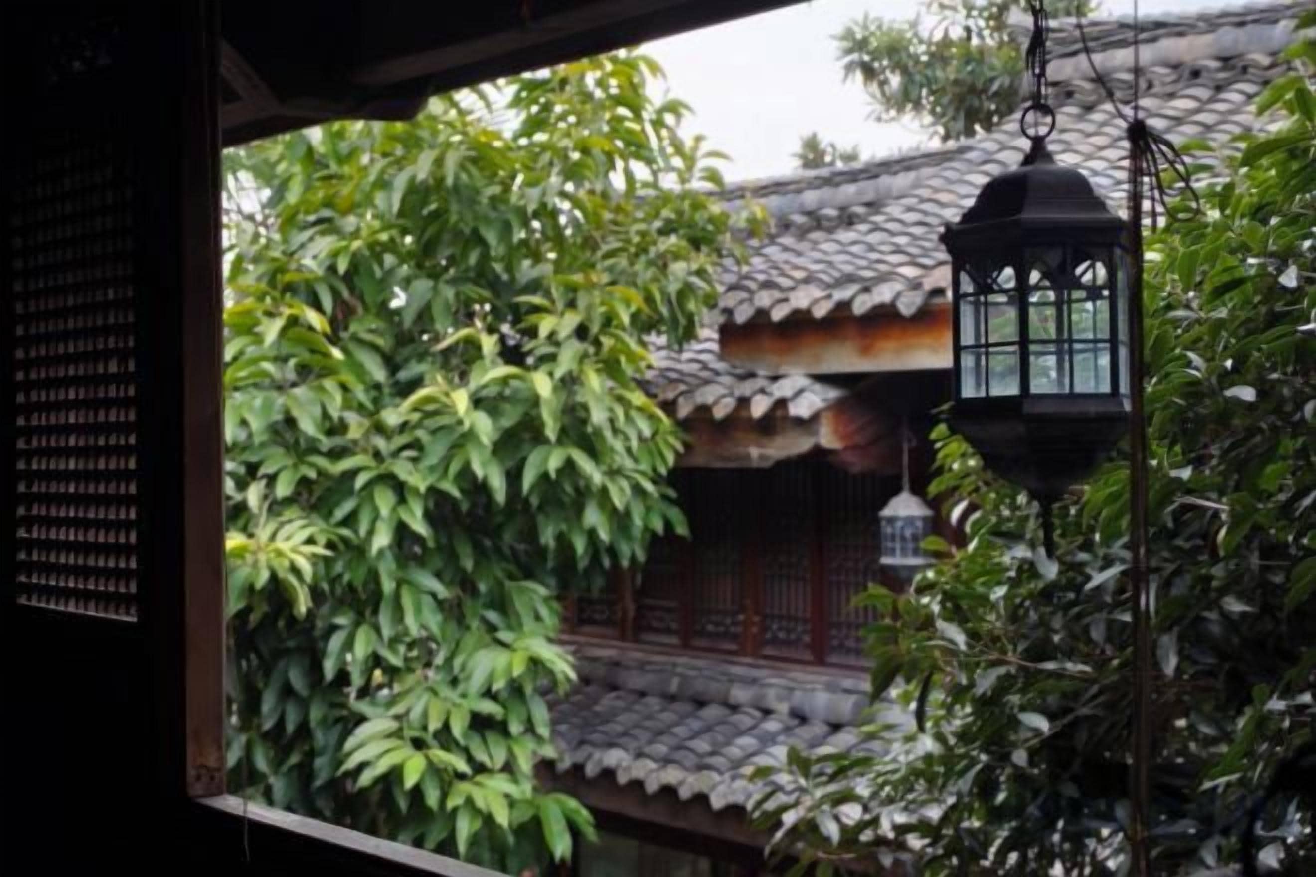 A traditional building with a tiled roof and a hanging lantern.