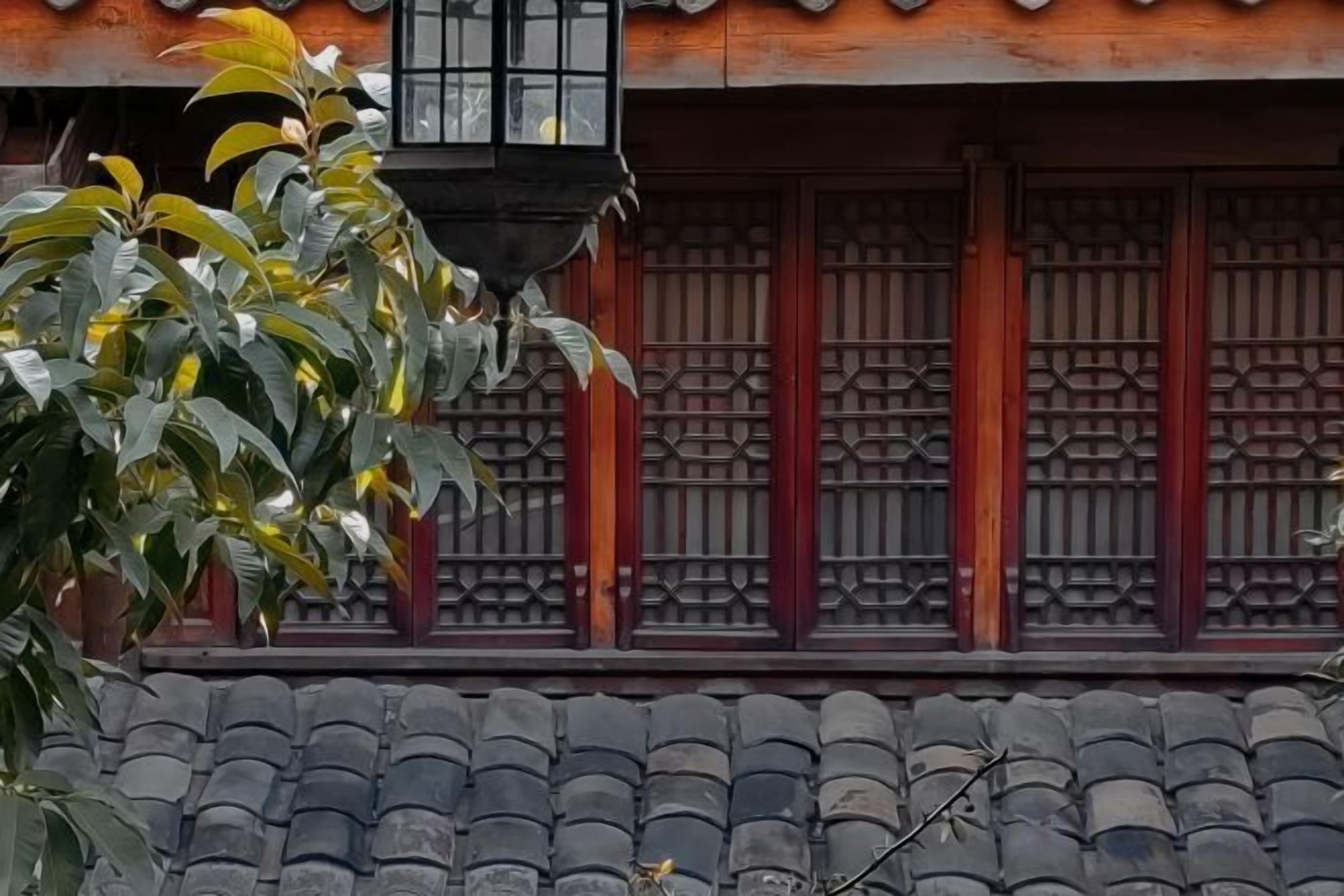 Un edificio tradicional con techo de tejas y una ventana con diseño de celosía.
