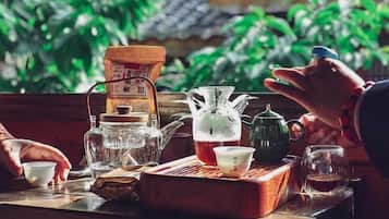A traditional tea setting with various tea utensils on a wooden tray, including a teapot, cups, and a sugar bowl.