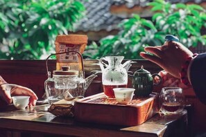 Un juego de té tradicional con diferentes utensilios para té sobre una bandeja de madera, incluyendo una tetera, tazas y un azucarero.
