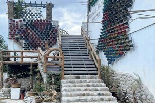 Una escalera conduce a un edificio con una decoración mural con forma de corazón y una estructura de madera a la izquierda.