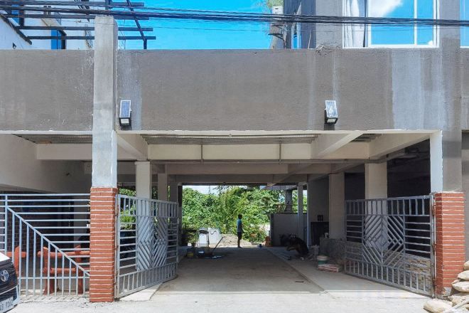 Un área de estacionamiento techada con portones metálicos y estructura de hormigón.
