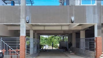Un área de estacionamiento techada con portones metálicos y estructura de hormigón.