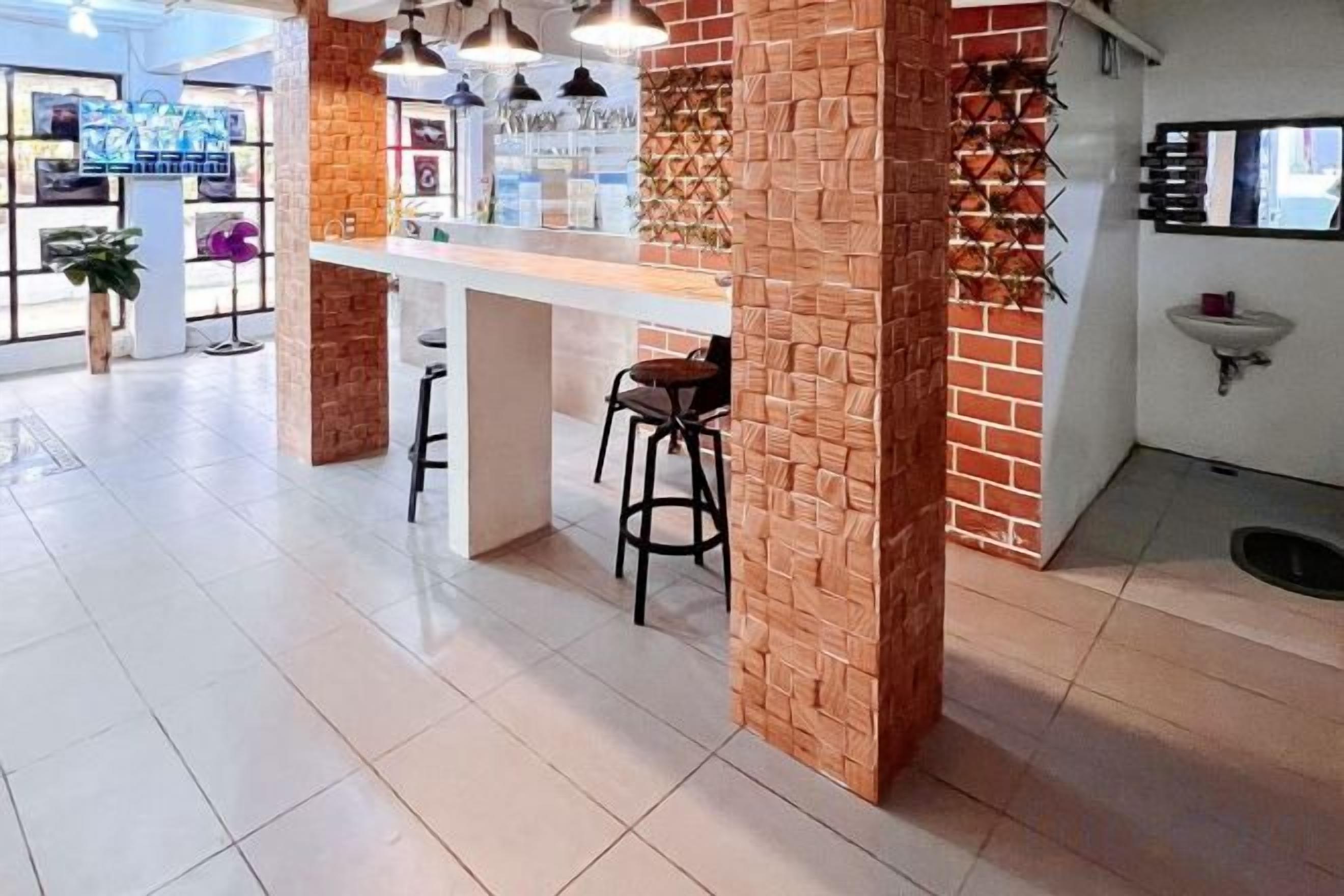 A modern bar area with a brick accent wall, bar stools, and pendant lighting.