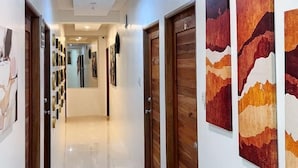 A hallway with wooden doors and artwork on the walls. - UrbanView @ Balzain East Tuguegarao City by RedDoorz (Tuguegarao)