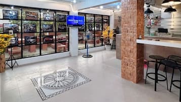 A modern interior with a reception area, a display of framed pictures, and a decorative floor pattern.