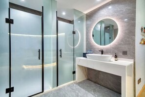 A modern bathroom with a glass shower enclosure, a white sink, and a marble wall. - see only hotel (Cixi)
