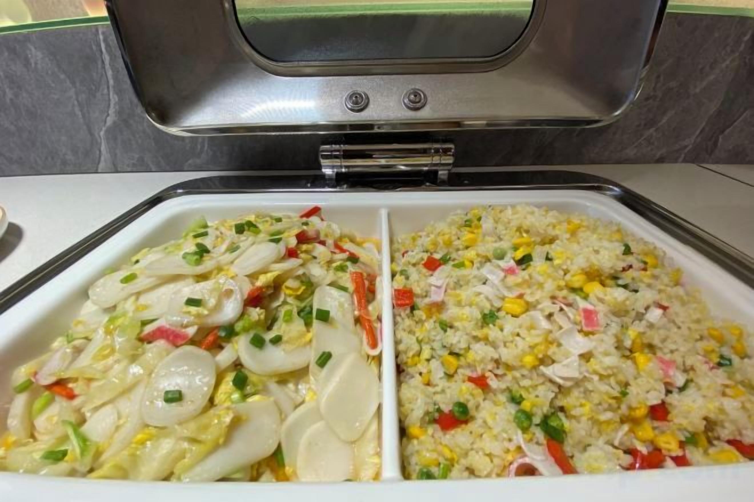A buffet with two sections of food, one with sliced eggs and vegetables, the other with rice and mixed vegetables.