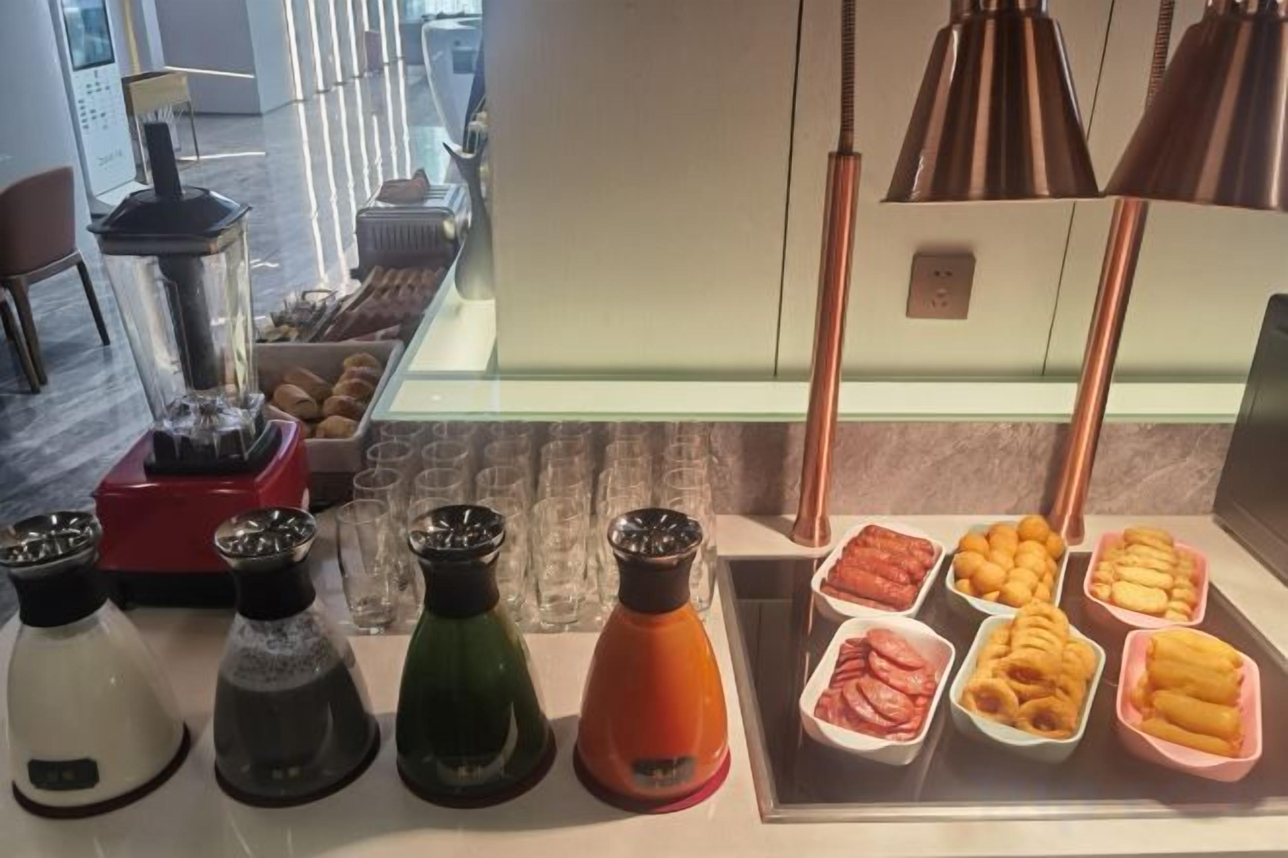 A kitchen counter with various condiments, a blender, and food items.