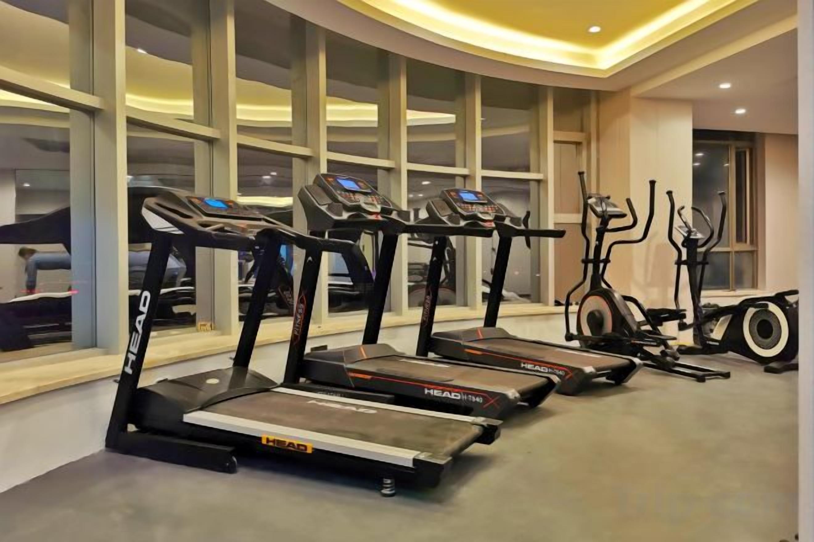 A gym with treadmills, elliptical machines, and stationary bikes.