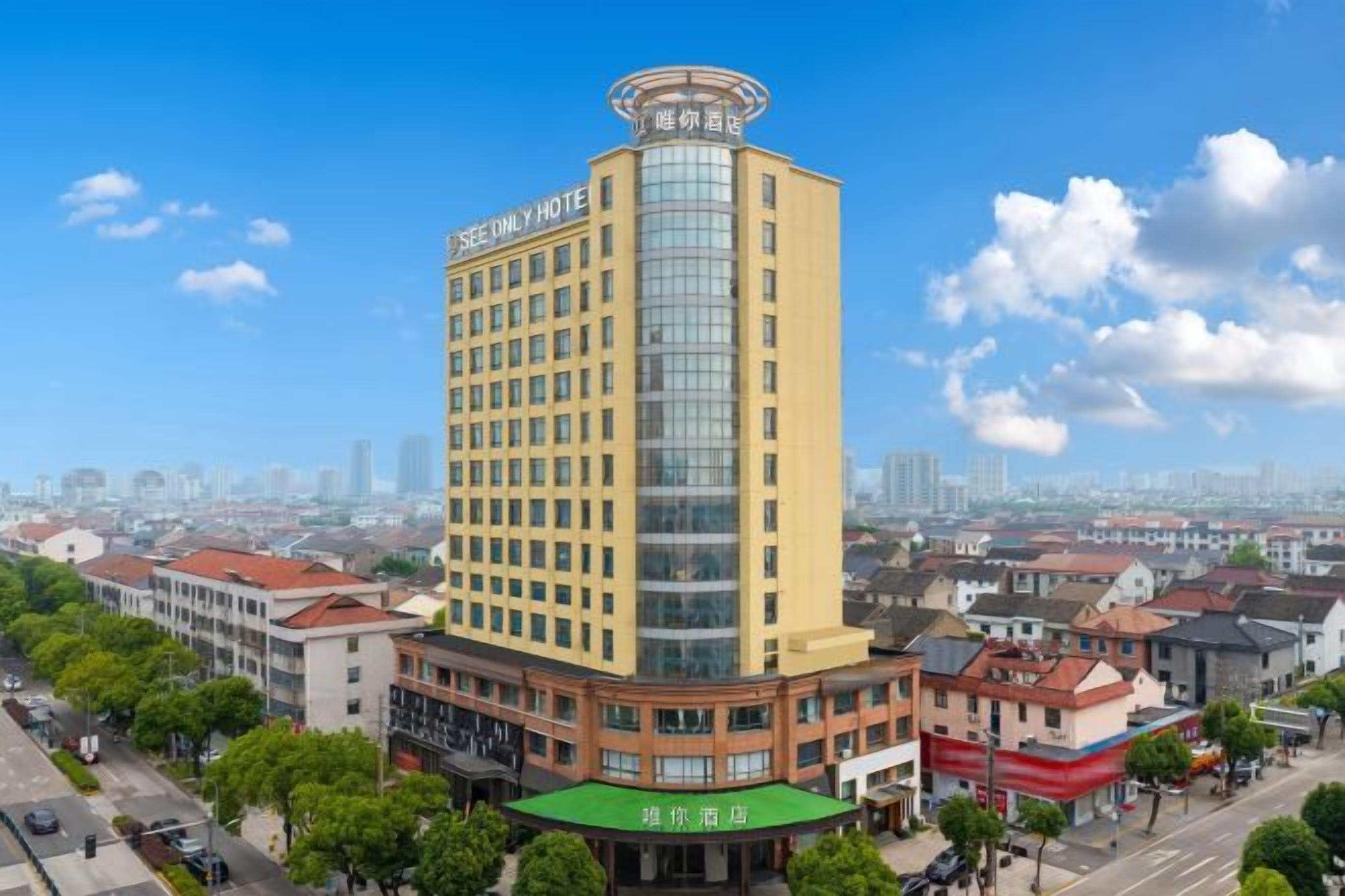 Ein mehrstöckiges Hotel mit markanter Ecklage, ausgestattet mit einer großen Glasfassade und einer Dachterrasse.