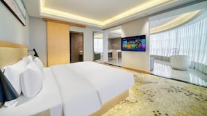 Hotelkamer met een bed, een televisie, een groot raam met gordijnen en een bad.