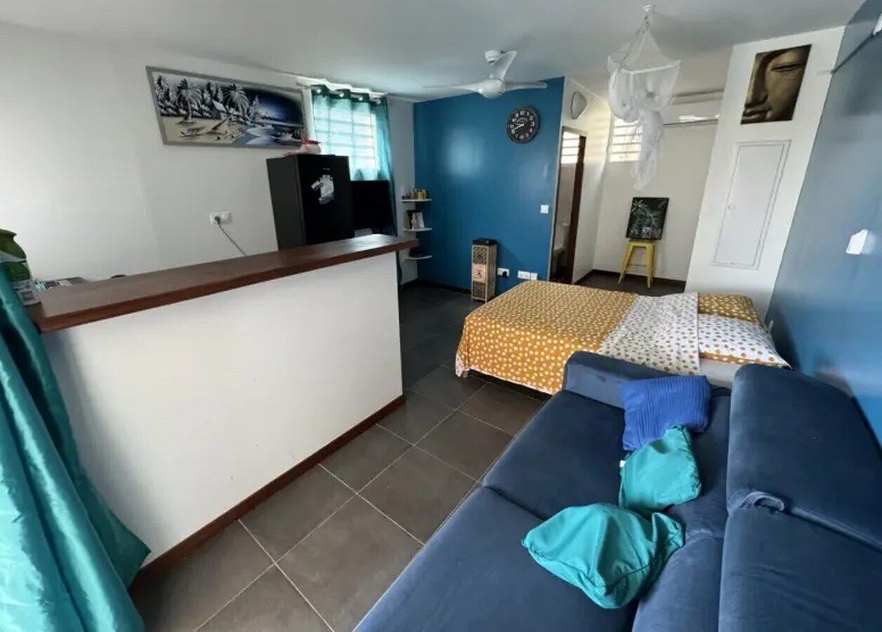 A room with a bed, a sofa, a desk, and a chair.