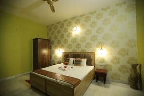 A bedroom with a bed, bedside tables, a wardrobe, and decorative wall lights.