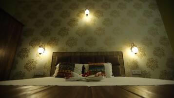 A neatly made bed with patterned pillows, a wooden headboard, and wall-mounted lamps.