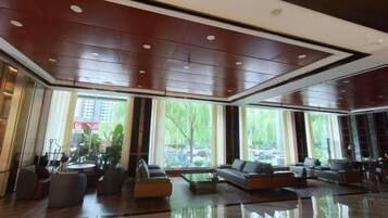 A spacious lobby with a polished floor, seating areas, and large windows offering views of the outside.