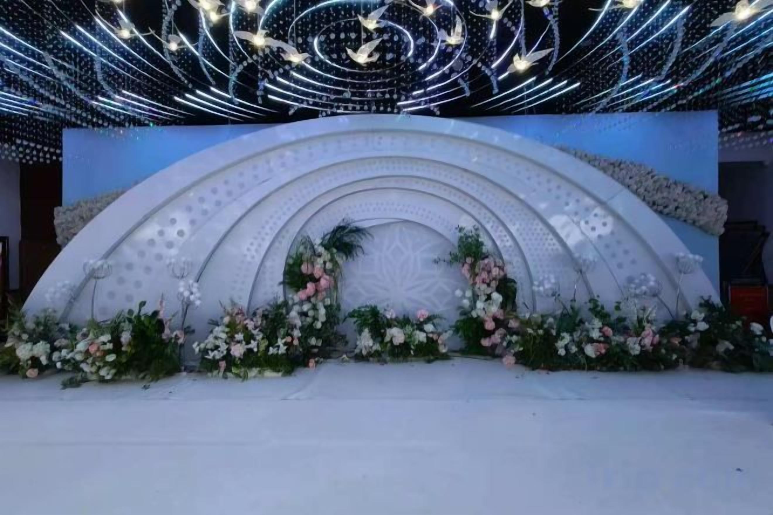 A stage with a floral arrangement and a geometric design.