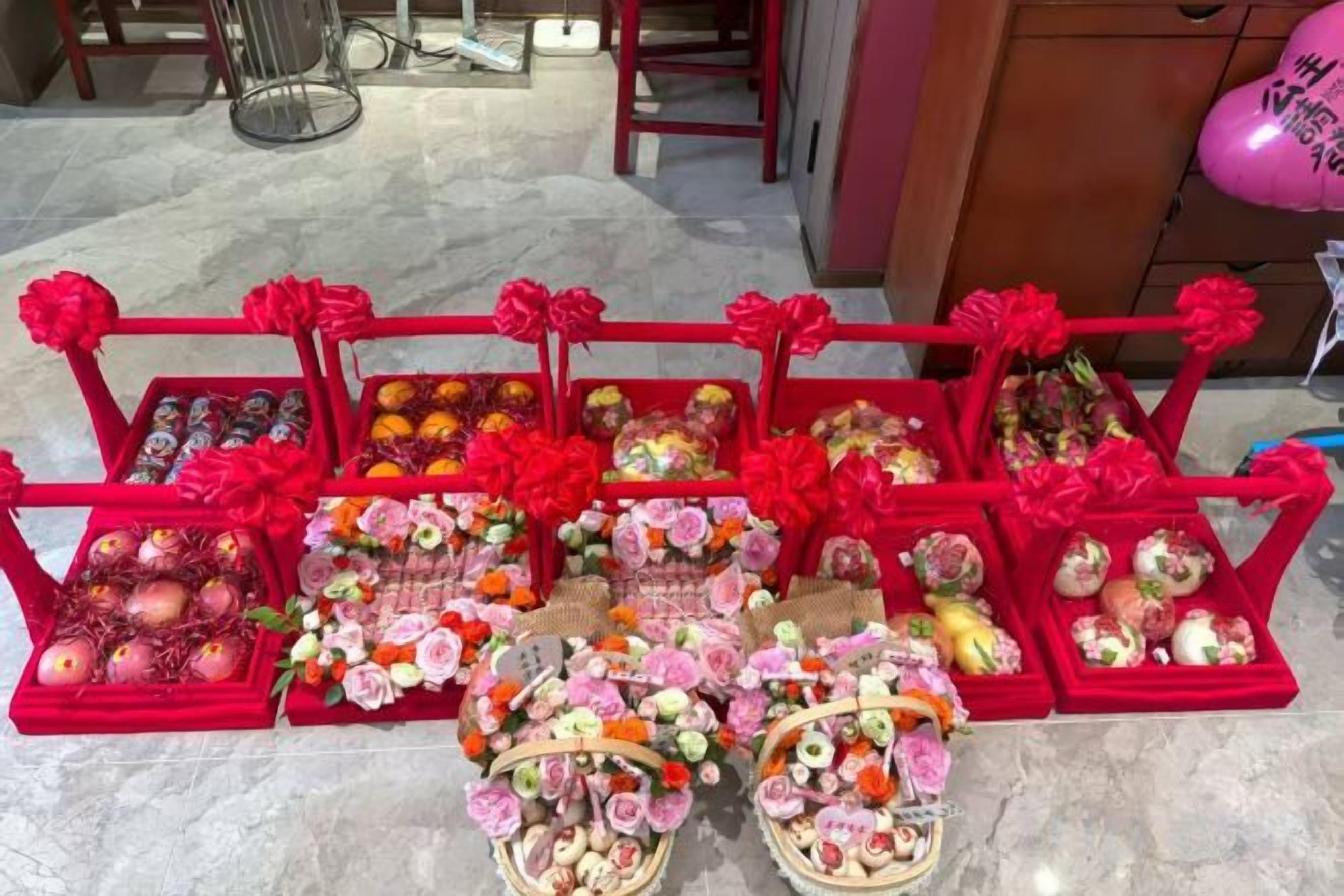 Una exhibición de diferentes alimentos y arreglos florales sobre pedestales rojos.