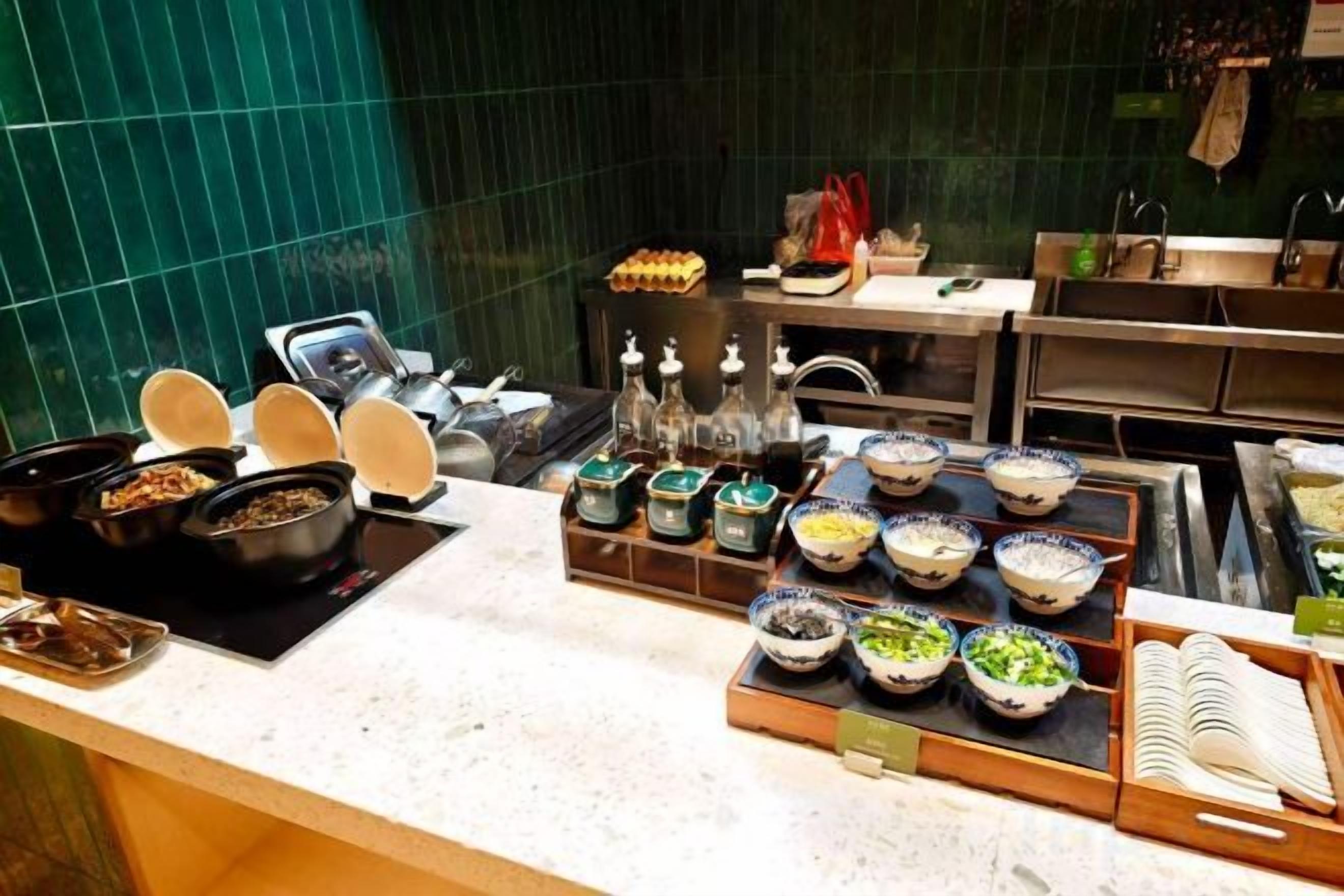 A buffet setup with various dishes and condiments.