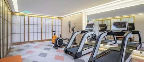 A fitness room with treadmills, a stationary bike, and a rowing machine.