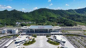 A modern airport terminal with a large, curved roof and multiple parking areas.