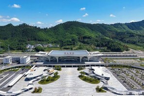 A modern airport terminal with a large, curved roof and multiple parking areas. - Madison Hotel Huangshan Scenic Area North Gate (Huangshan City)