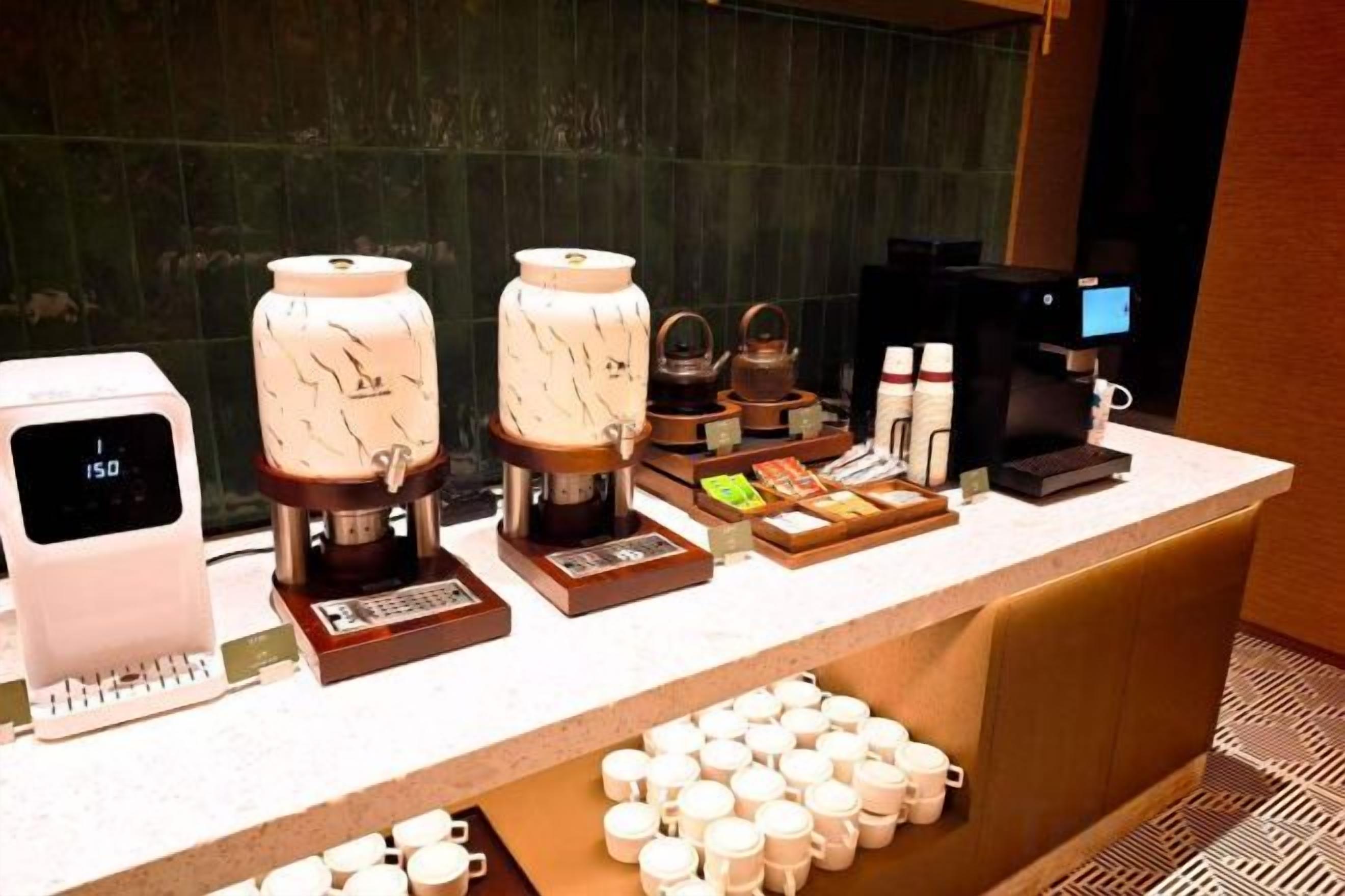 A coffee station with multiple coffee machines, a scale, and a variety of coffee pods and cups.