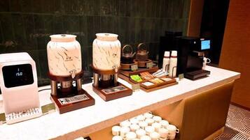 A coffee station with multiple coffee machines, a scale, and a variety of coffee pods and cups.