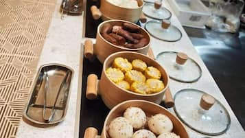 Montaje de bufé con diferentes alimentos en cuencos y recipientes de madera.