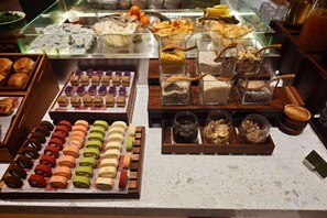A display of assorted pastries and desserts in a bakery section. - Madison Hotel Huangshan Scenic Area North Gate (Huangshan City)