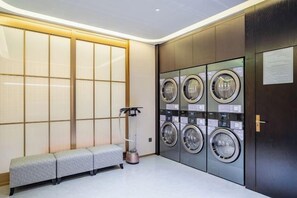 Un cuarto de lavandería con un banco, una lavadora y una secadora.