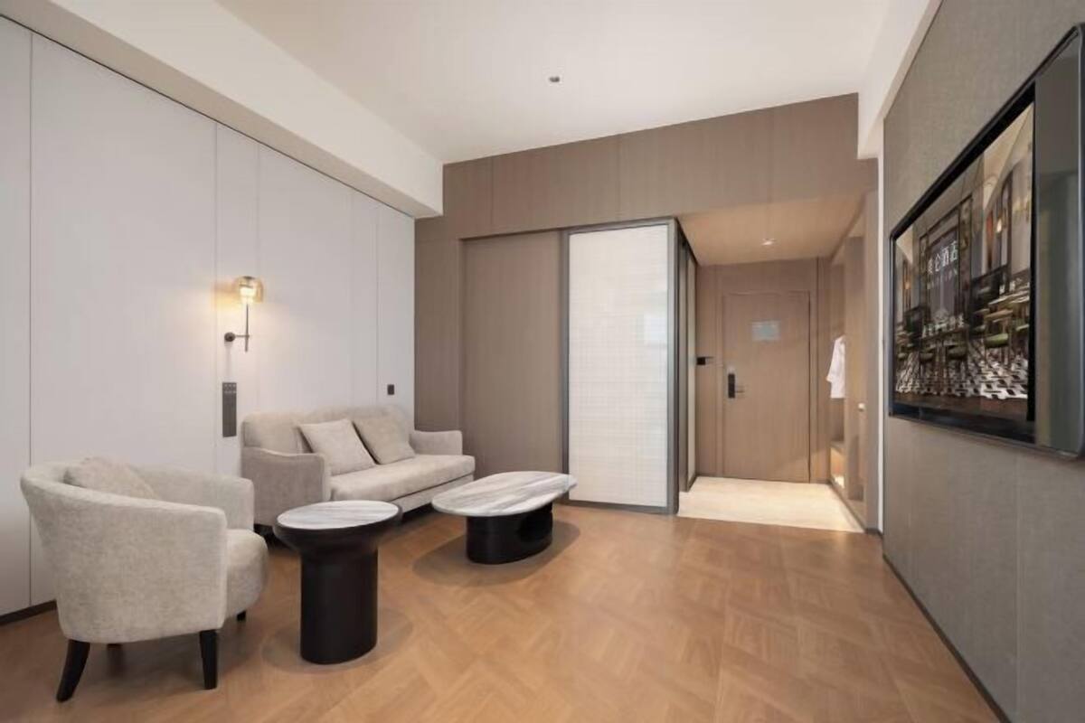 Ein modernes Hotelzimmer mit Sofa, Sesseln und Couchtisch.