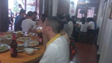Un comedor con mesas dispuestas para varias personas, una variedad de platos y una botella de cerveza.