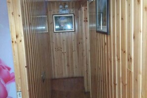 A wooden interior with a framed picture on the wall, a door, and a small window. - Yongjia Yongping Home Inn (Yongjia)