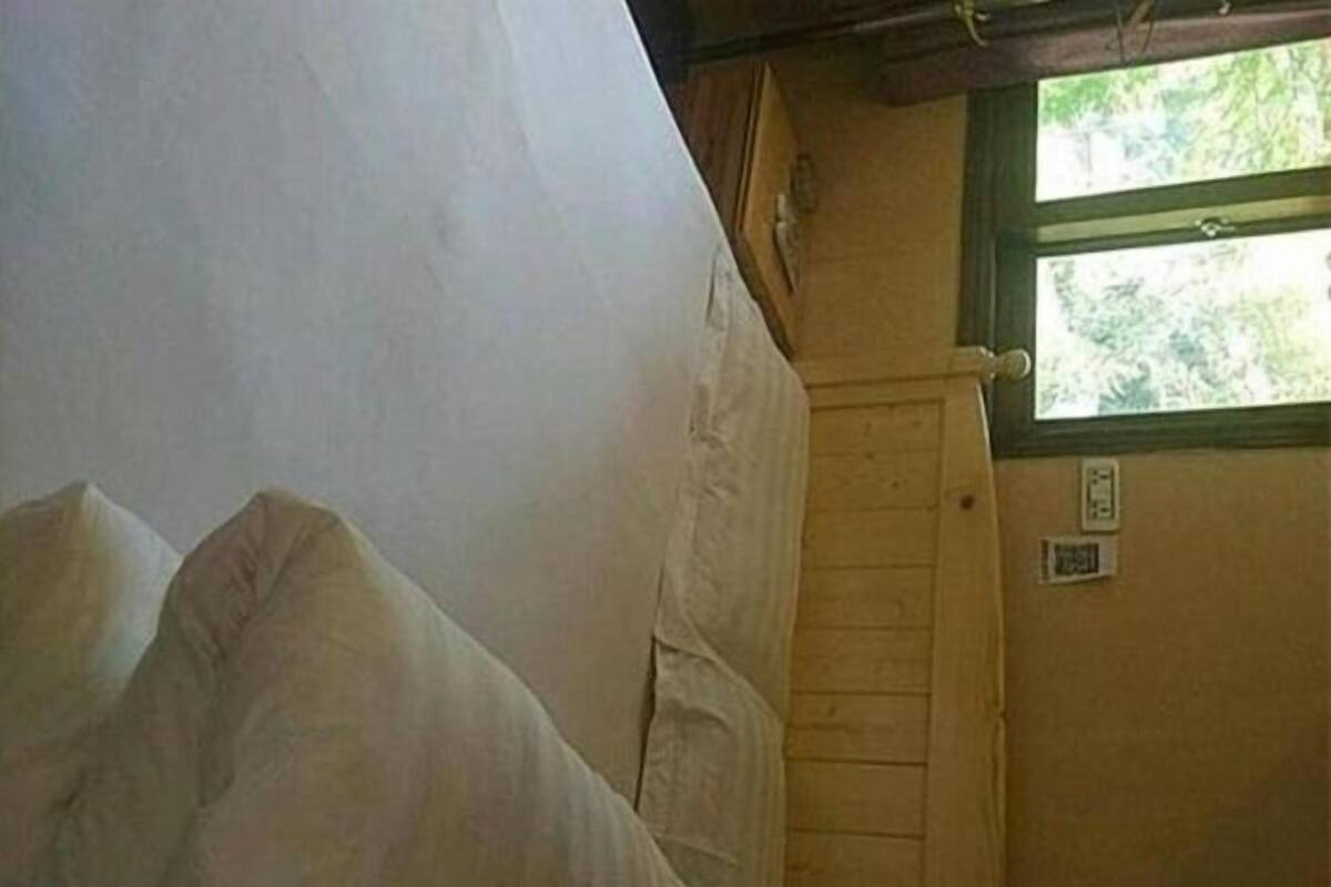 Ein Zimmer mit Bett, Fenster und Tür.