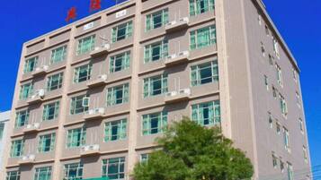 Un edificio de varios pisos con un cielo azul despejado al fondo.