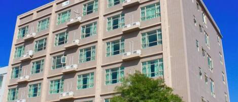 Un edificio de varios pisos con un cielo azul despejado al fondo.