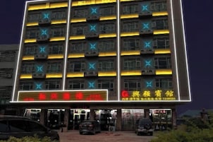 Hotel de vários andares com letreiros iluminados e aparelhos de ar condicionado.