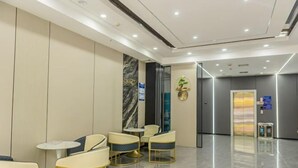 Een moderne hotel lobby met zithoeken, een receptiebalie en een duidelijke route naar de lift.