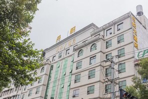 A multi-story building with a series of windows and a green awning. - Danyang Hotel (Guiyang)