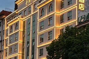 A multi-story hotel building with illuminated windows and a visible sign indicating it is a hotel.