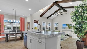 A spacious kitchen with a large island, modern appliances, and a dining area with a table and chairs. - Experience the irresistible charm of Cayo Coco Cottage! (Naples)