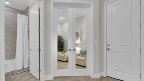 A hallway with a double door leading to a living area, a shower, and a tiled floor. - Experience the irresistible charm of Cayo Coco Cottage! (Naples)