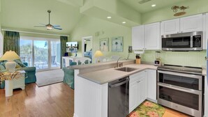 A modern kitchen with white cabinets, a microwave, an oven, and a dishwasher.