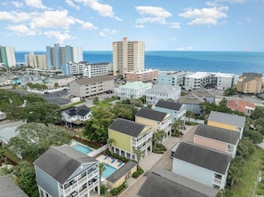 A coastal residential area with various buildings, including multi-story apartments and houses, with a view of the ocean.