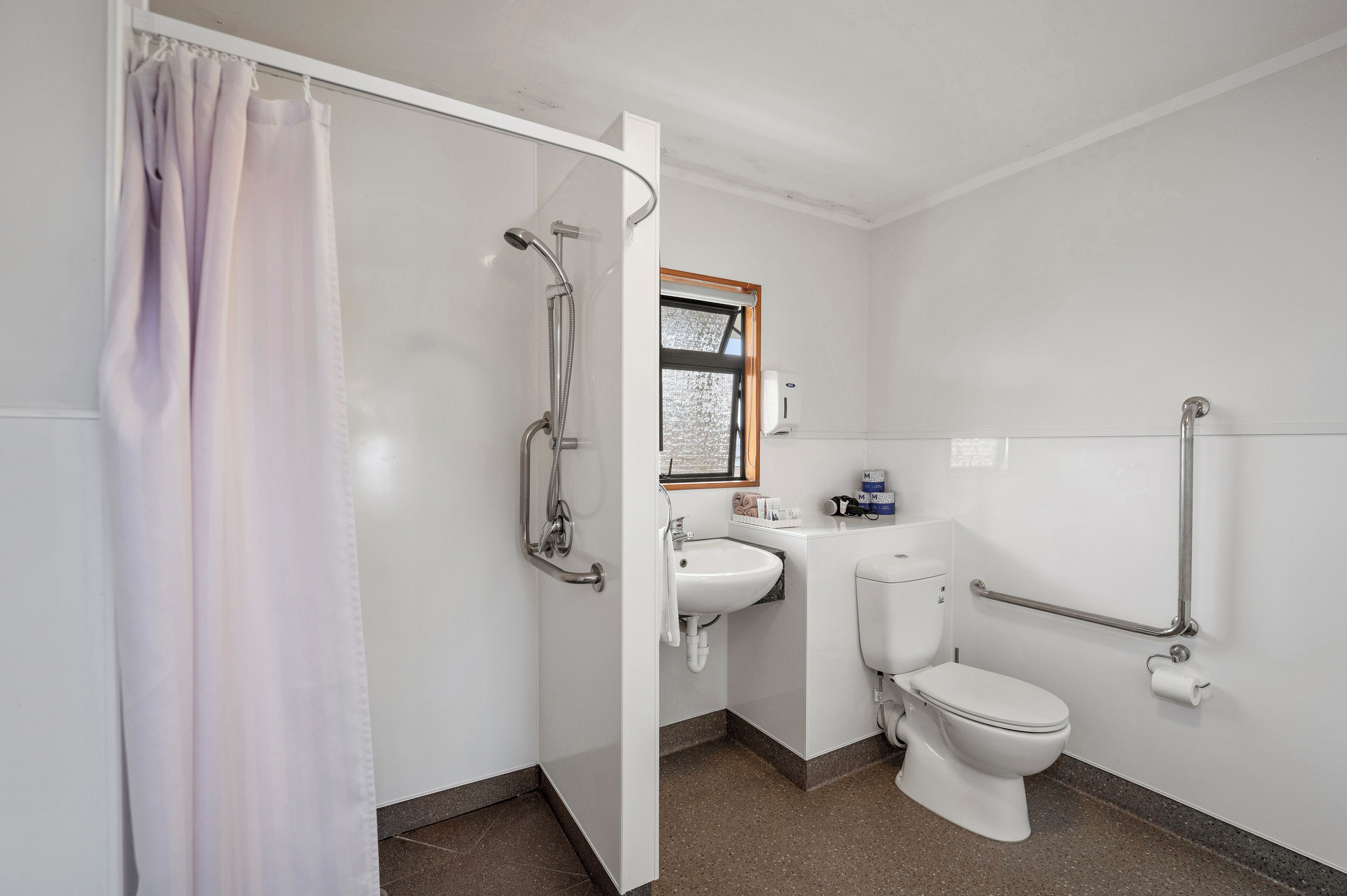 Un baño con ducha, inodoro y lavamanos.