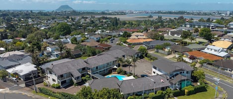 A residential area with houses, a swimming pool, and a road.