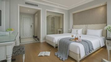 A hotel room with a bed, bedside table, and a desk with a chair.
